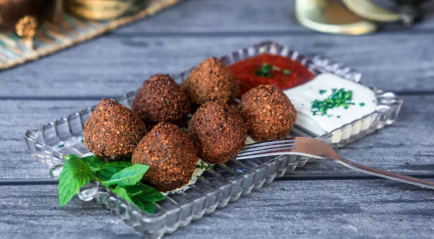 Falafel Regular - Classic falafel with hummus, lettuce, tahini and shatta sauce.