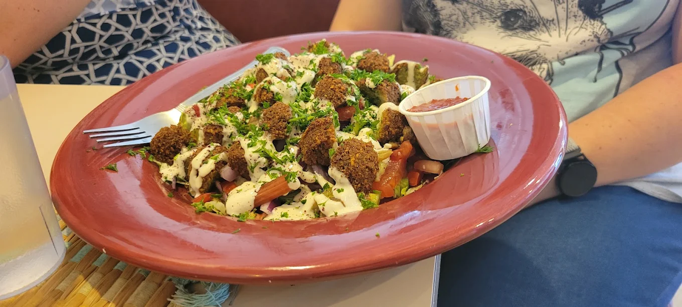 King Falafel Salad - Our signature salad topped with crispy falafel and fresh Mediterranean vegetables.